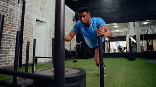 Man performing sled push in gym