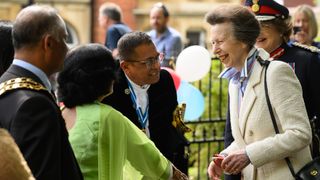 Princess Anne speaks with dignitaries as she visits a Coronation street party