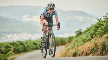 Female cyclist riding up a hill