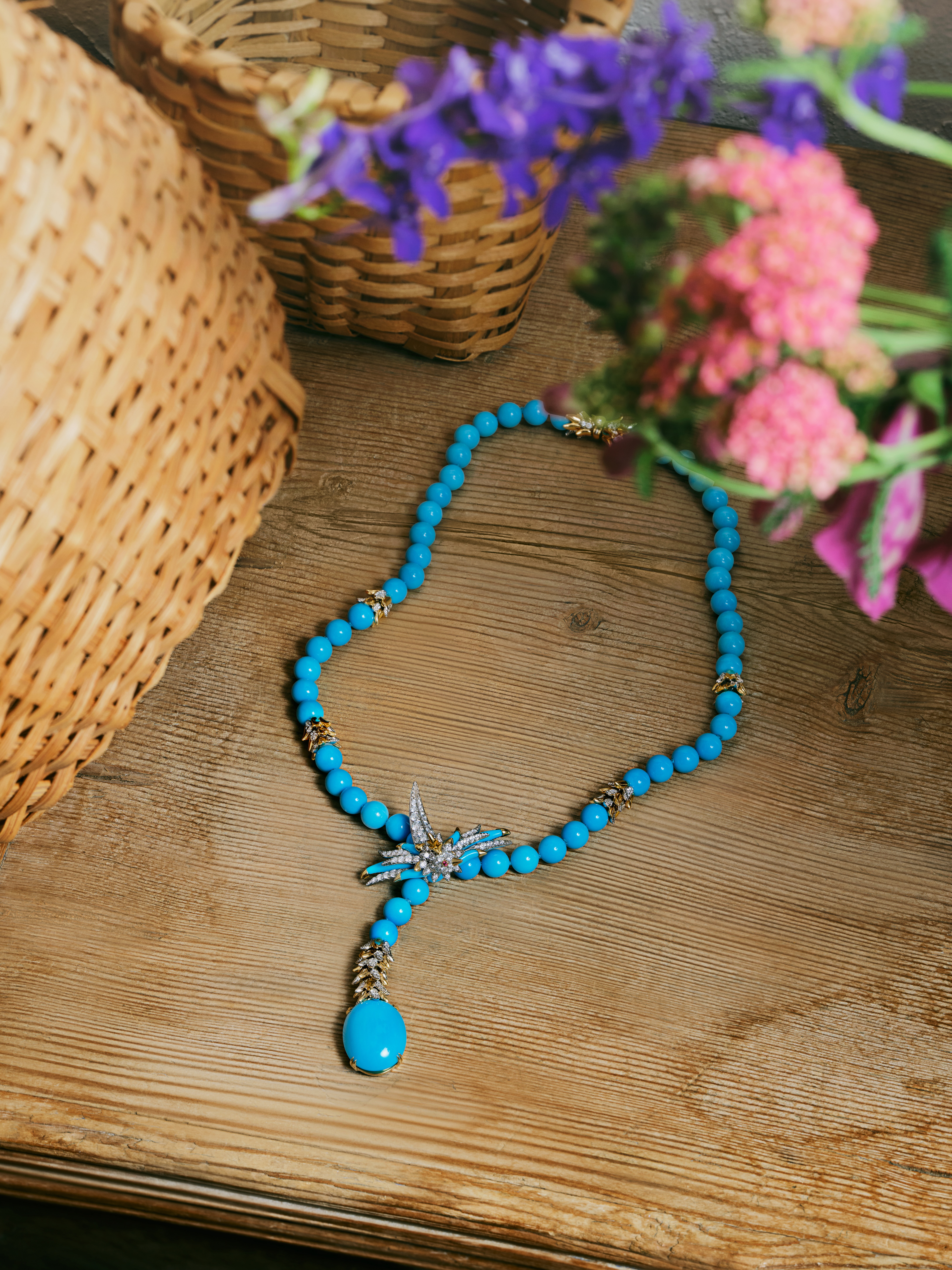 Turquoise and diamond bead necklace photographed on a wooden table