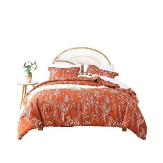 An orange floral bedding set with a woven headboard
