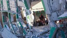 Palestinian teacher Doha al-Attar, 30, a mother of four from Rafah, runs a class for children in a heavily damaged classroom in Khan Yunis