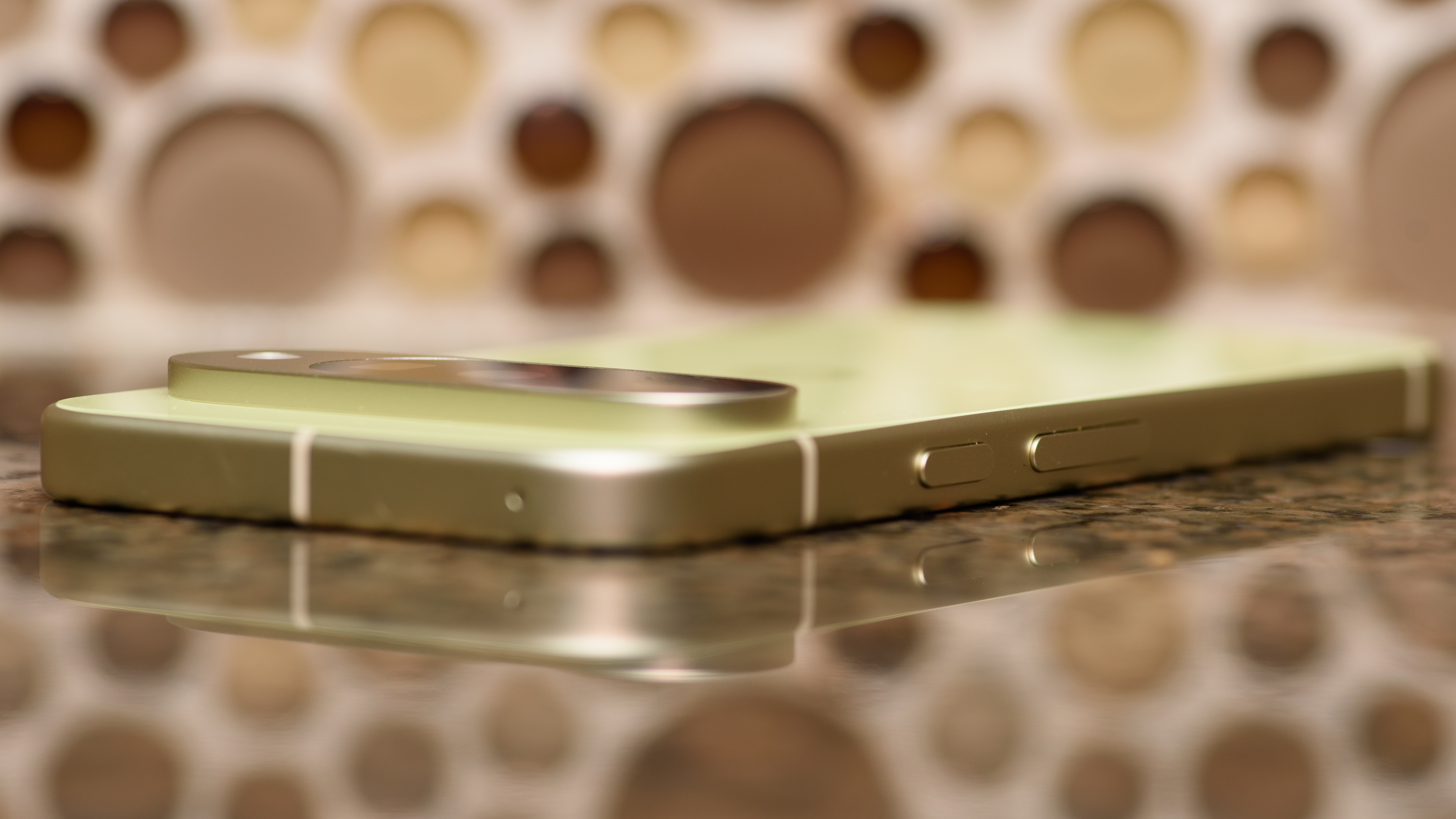 Google Pixel 10 in Lemongrass against a bubbly backsplash