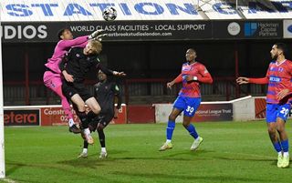 DAGENHAM, ENGLAND - JANUARY 21: Airidas Golambeckis of West Ham United battles with Dagenham & Redbridge goalkeeper, Nathan Harvey during the National League Cup match between Dagenham & Redbridge and West Ham United U21's at Chigwell Construction Stadium on January 21, 2025 in Romford, England. (Photo by West Ham United FC/West Ham United FC via Getty Images)