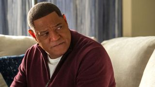 Laurence Fishburne as Doc Rivers sitting in a hotel room in Clipped episode 3