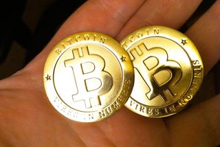 Two Bitcoins in a person's hands