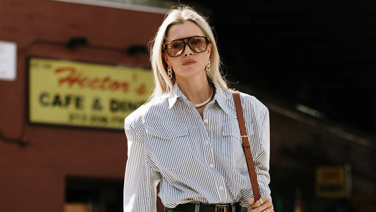 a Woman wearing a striped button-down shirt and oversized sunglasses in New York 