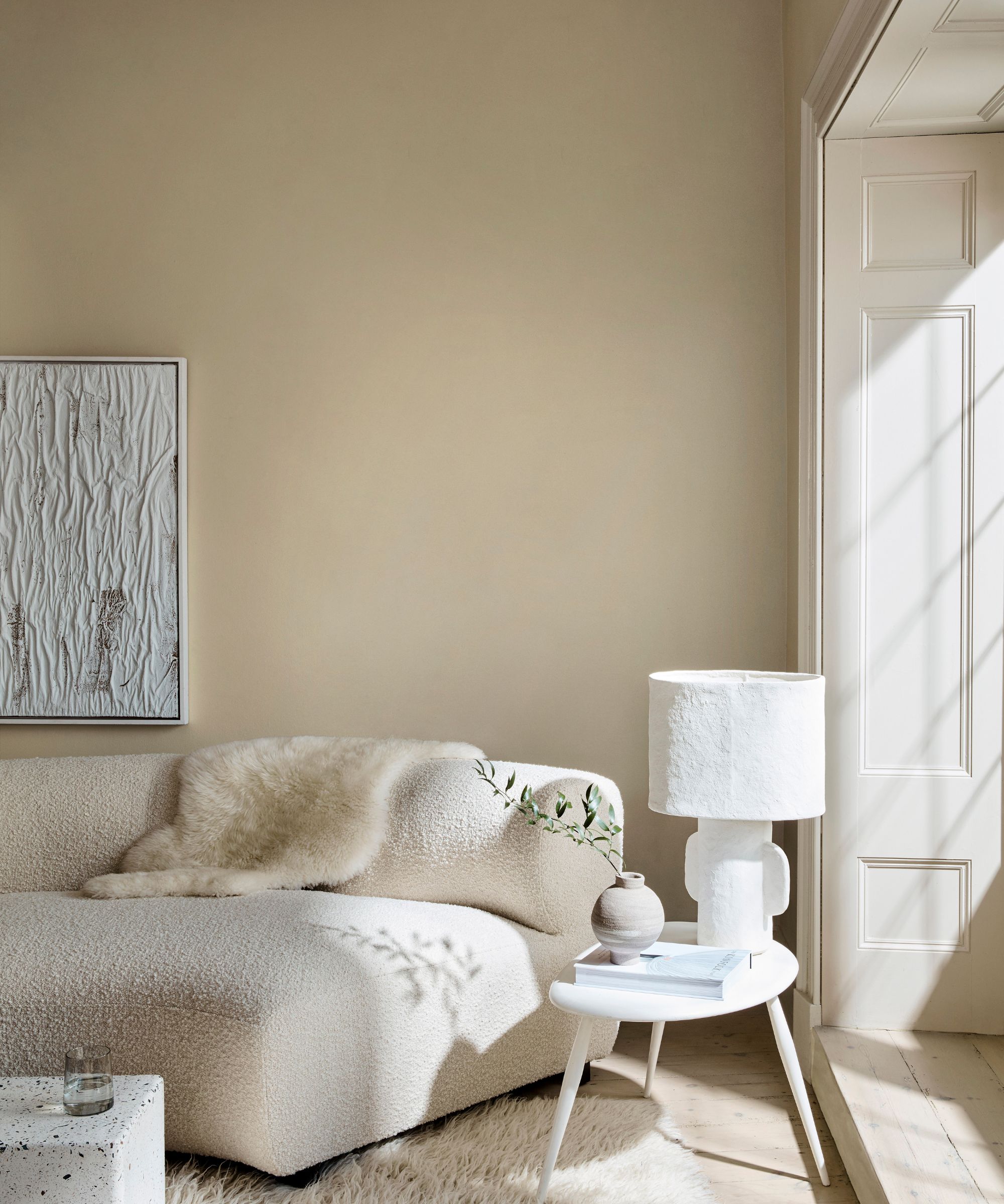 cozy living room with beige walls and white decor with sunlight streaming in