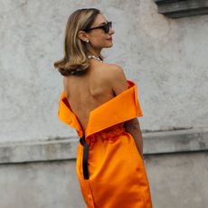Jenny Walton wearing an orange double-satin Prada dress during Milan Fashion Week.
