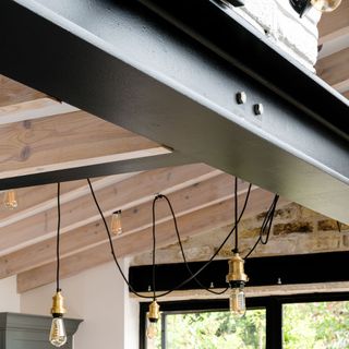 iron beam on ceiling and rope light bulbs on wooden beam