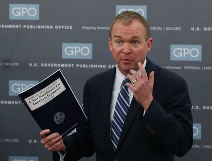 Mick Mulvaney holds up a copy of Trump's fiscal 2018 blueprint