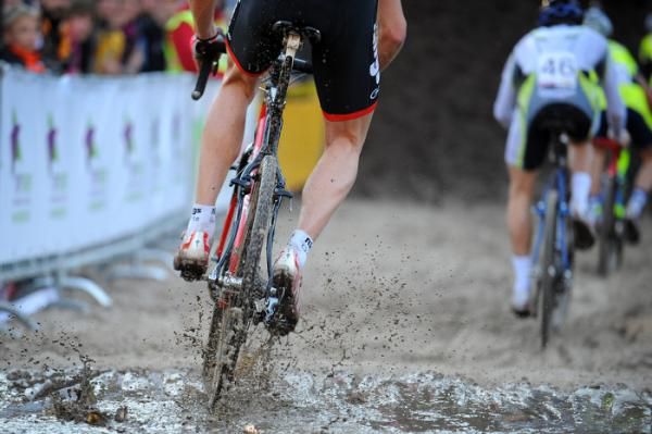 An elite men's rider flies through the mud.