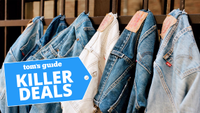 Row of jeans in various washes hanging from hooks with Killer Deals badge treatment
