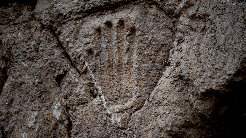 A handprint carved into a stone wall. 