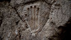 A handprint carved into a stone wall. 