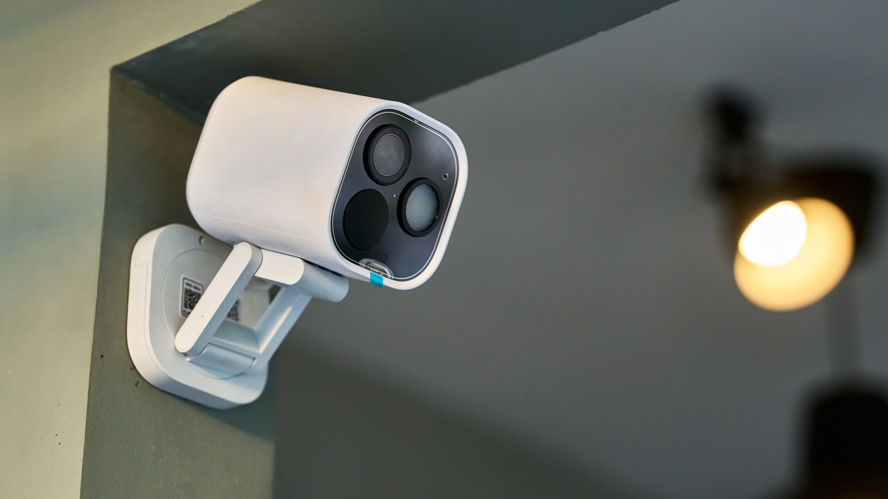 Home security camera mounted on interior wall