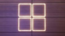 Windows logo illuminated in warm white lighting against a purple backdrop pictured at the 2024 Mobile World Congress (MWC) event in Barcelona, Spain.
