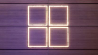 Windows logo illuminated in warm white lighting against a purple backdrop pictured at the 2024 Mobile World Congress (MWC) event in Barcelona, Spain.