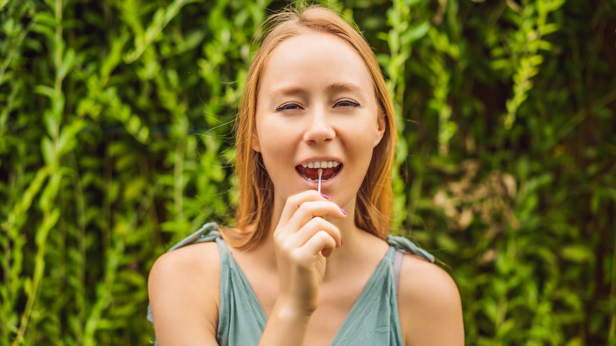 Woman doing DNA test with cotton swab.