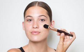 model applying foundation with a foundation brush