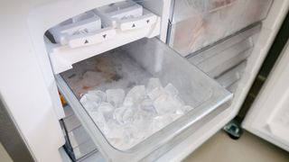 Ice maker in the refrigerator with some ice cubes