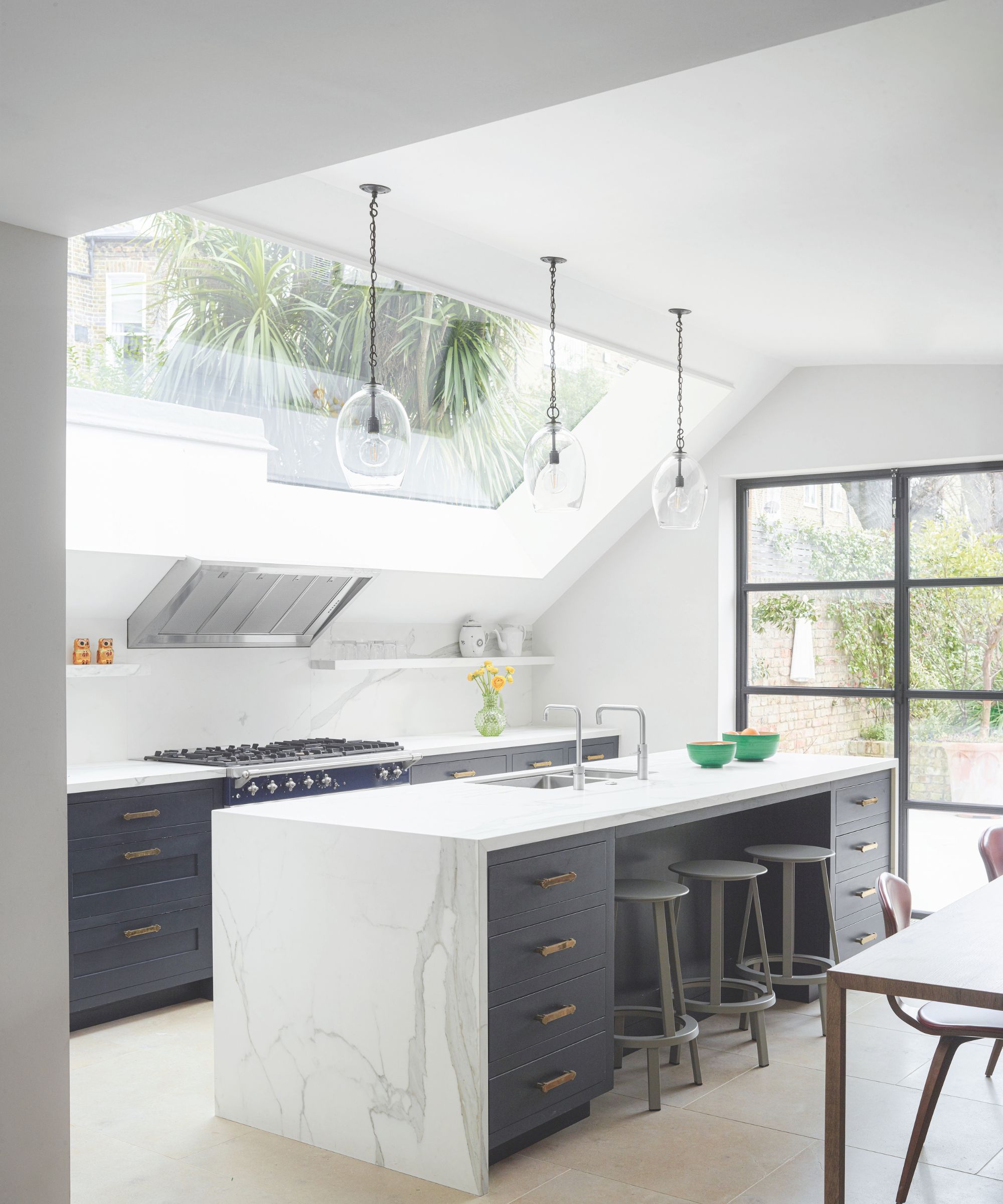 Dark grey kitchen with white marble counters and island
