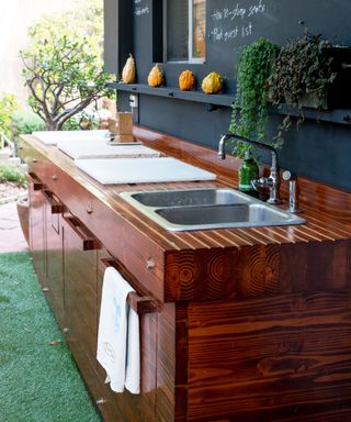 wooden outdoor kitchen with sink and food prep areas