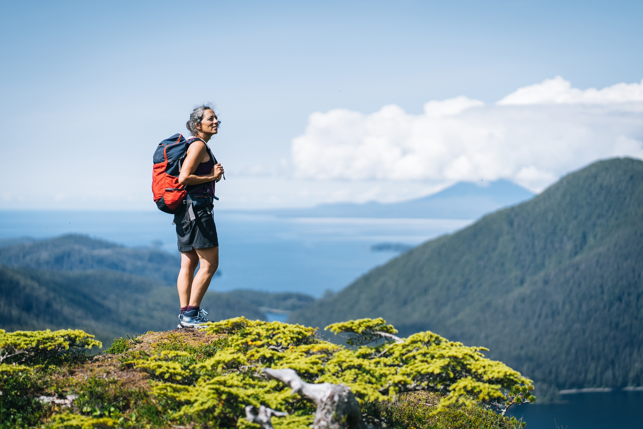 An active Alaskan senior on a hike on a mountain peak, representing the unique healthcare and Medicare challenges of the Last Frontier.