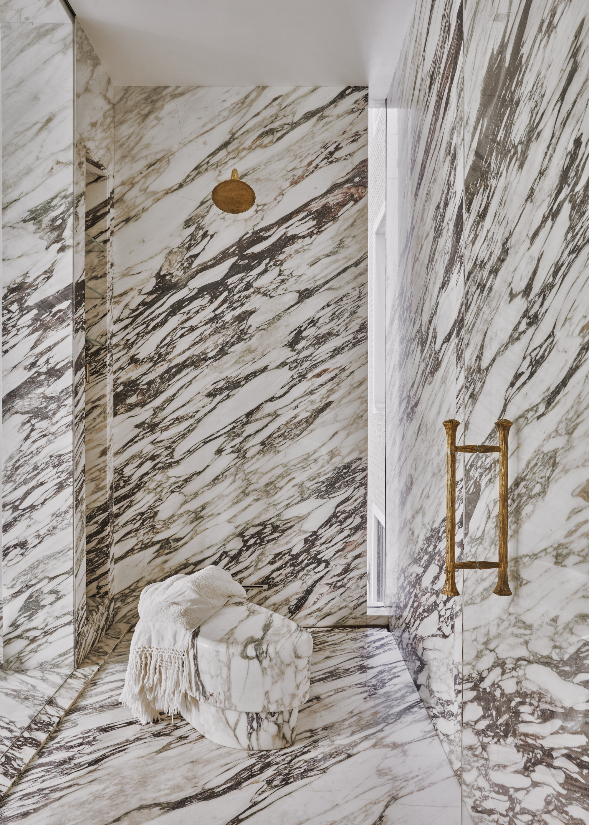 A walk-in shower with drenched in high contrast marble