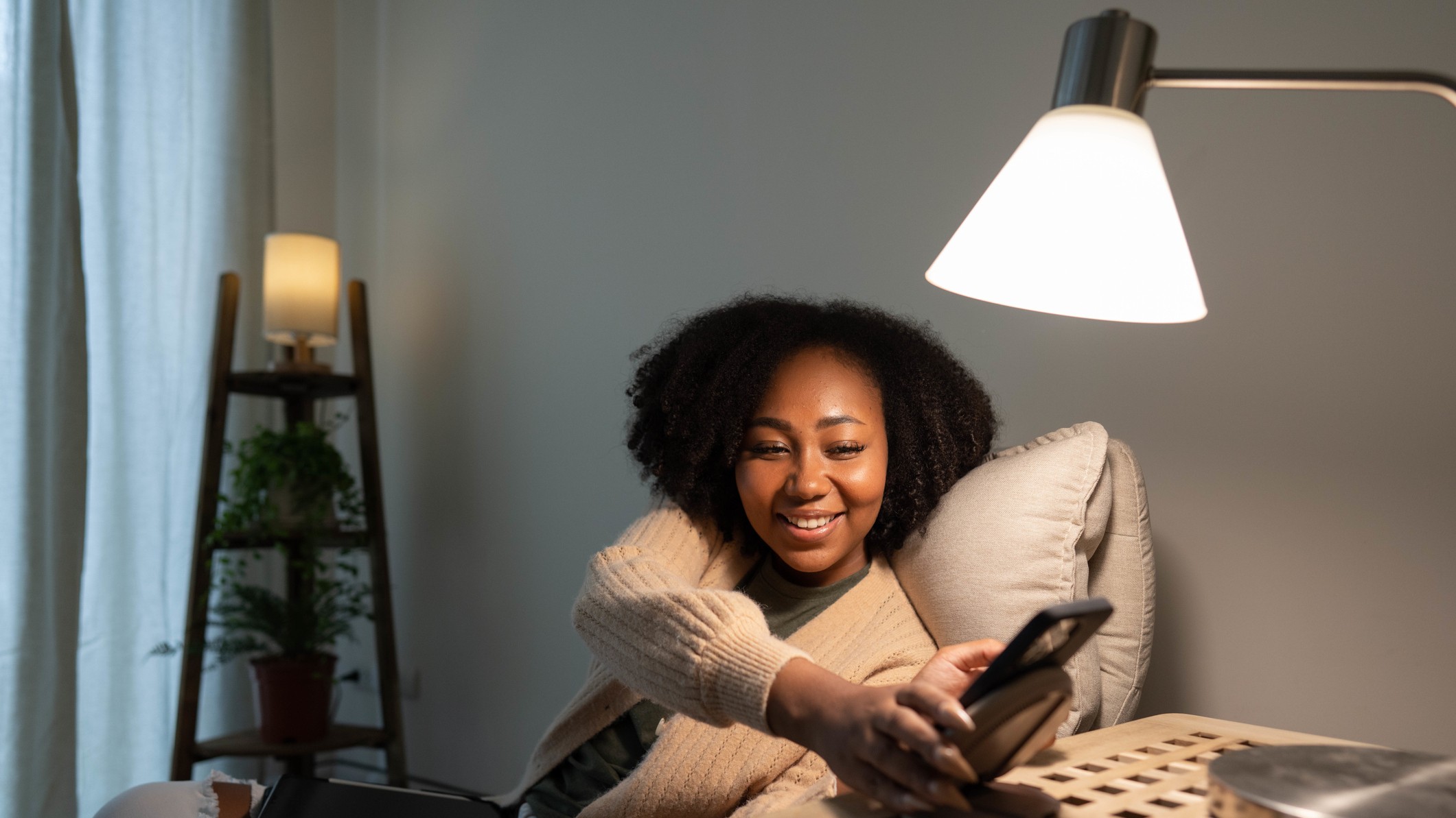 Woman looking at phone under lamp