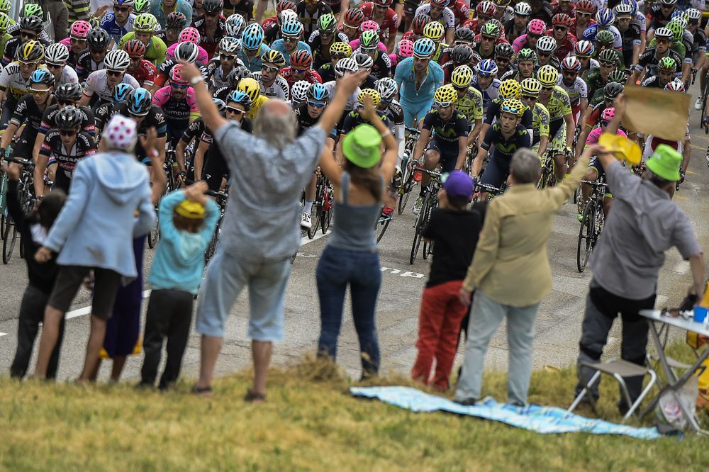 Spectators cheer as the peloton passes.