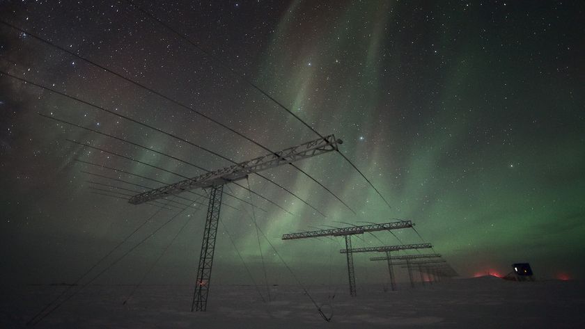 A photo of auroras over the South Pole with antennas and electrical wires visible