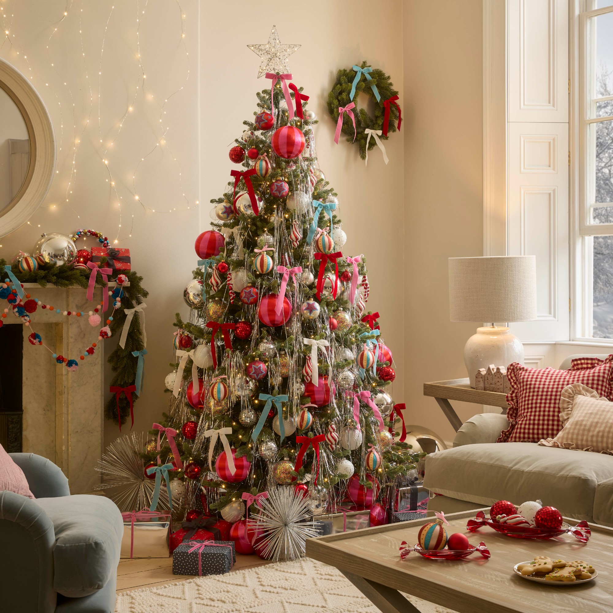 A living room with a Christmas tree decorated with silver lametta tinsel and multicoloured bows