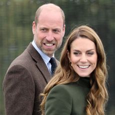 Kate Middleton and Prince William smiling and wearing coats