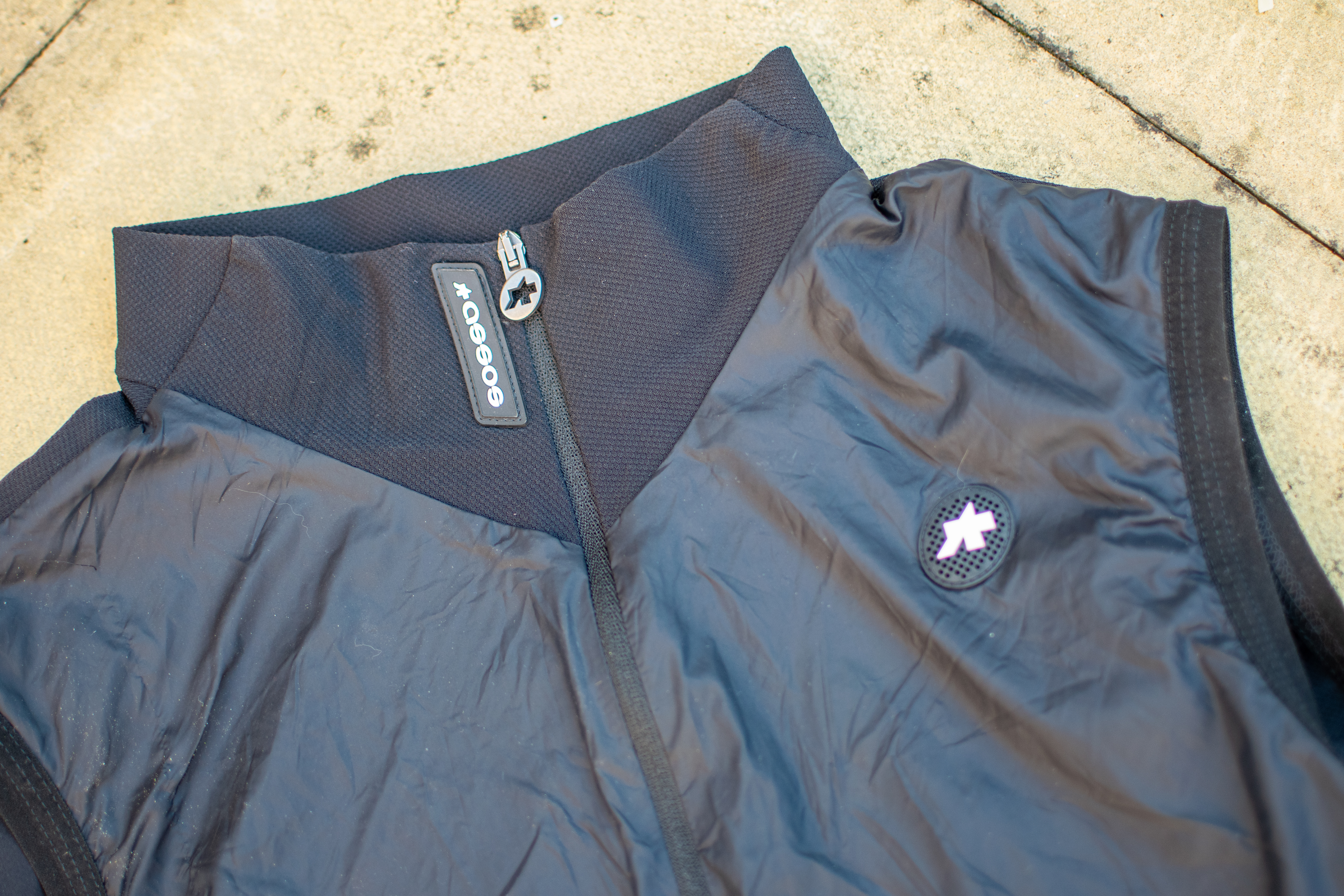 A black Assos Tactica T5 vest on some paving slabs