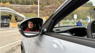 Mirror reflection of Julia Clarke in driver's seat of the Jeep Avenger 4Xe TNF edition