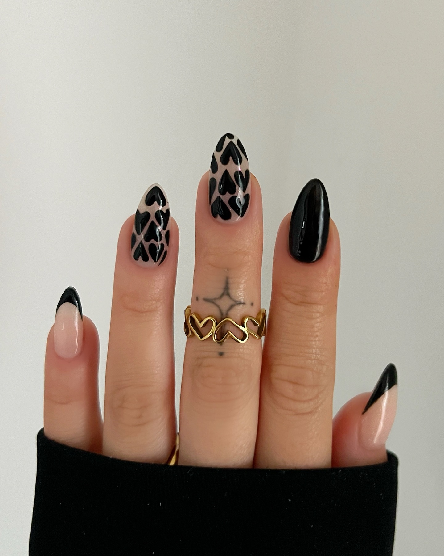 A manicure with black French tips and heart nail art by Charlotte Cliff