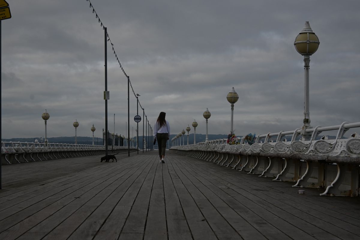 Girl walking down a seaside promenade