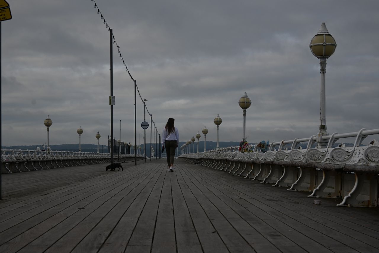 Girl walking down a seaside promenade