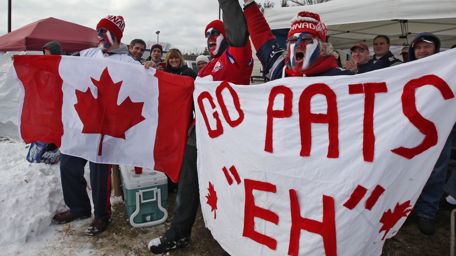 New England Patriots fans waving a Canada flag before an NFL game.