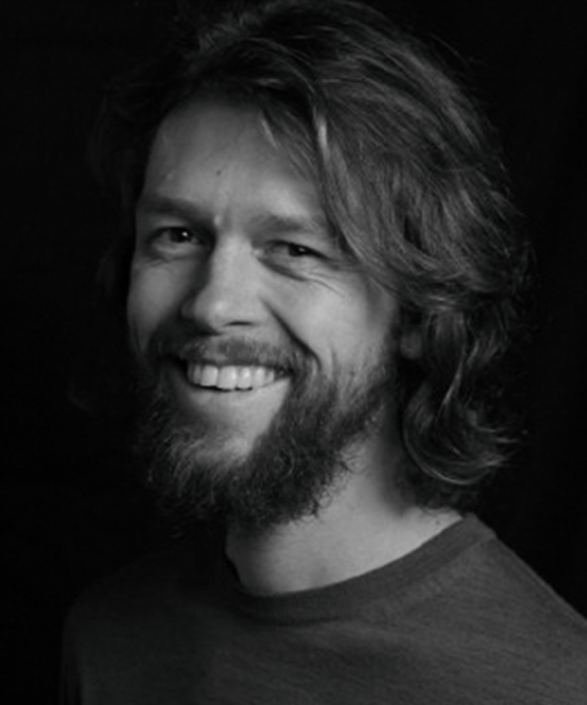 black and white headshot of male with beard