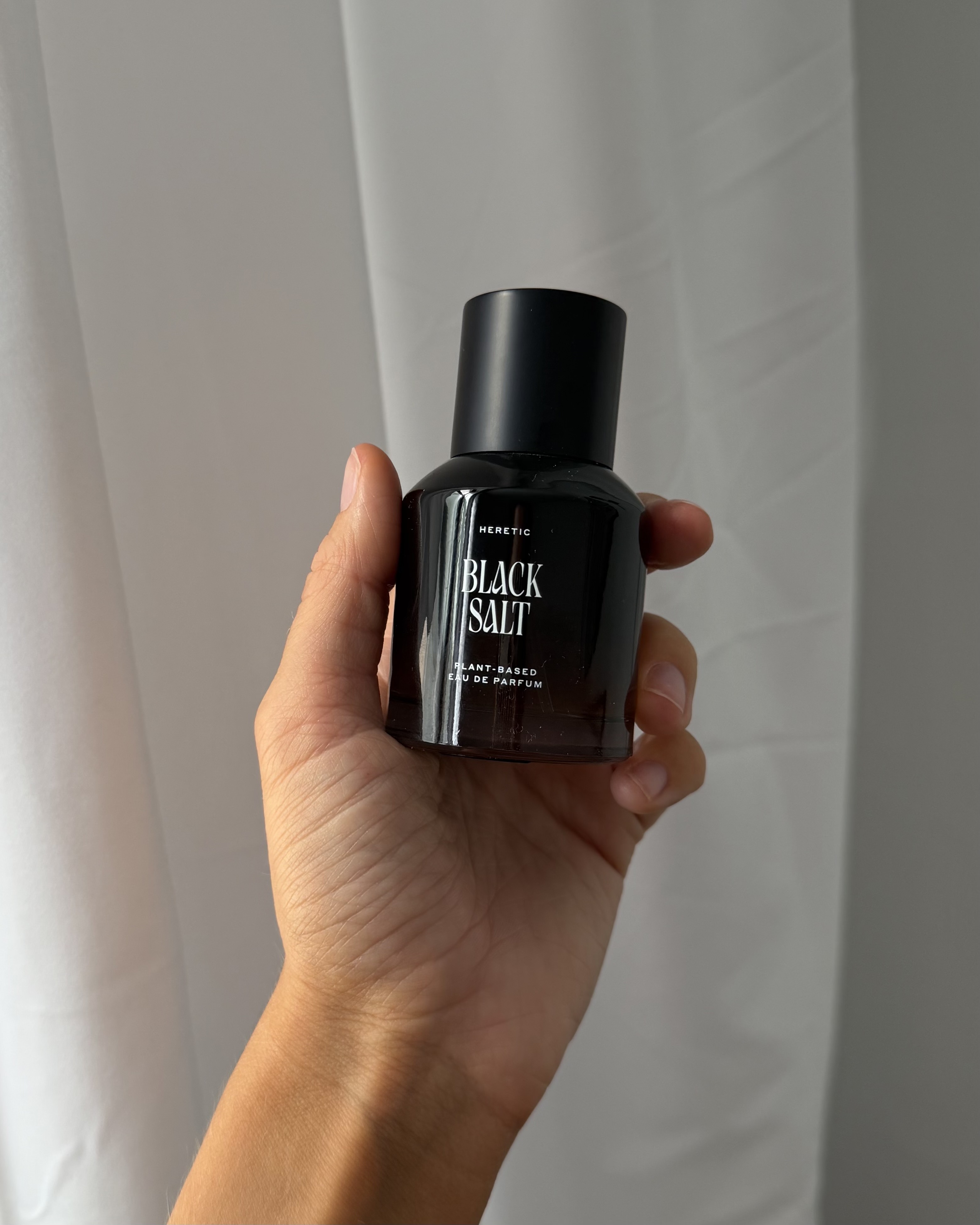 Who What Wear associate beauty editor Alyssa Brascia holding the Heretic Black Salt Eau de Parfum.