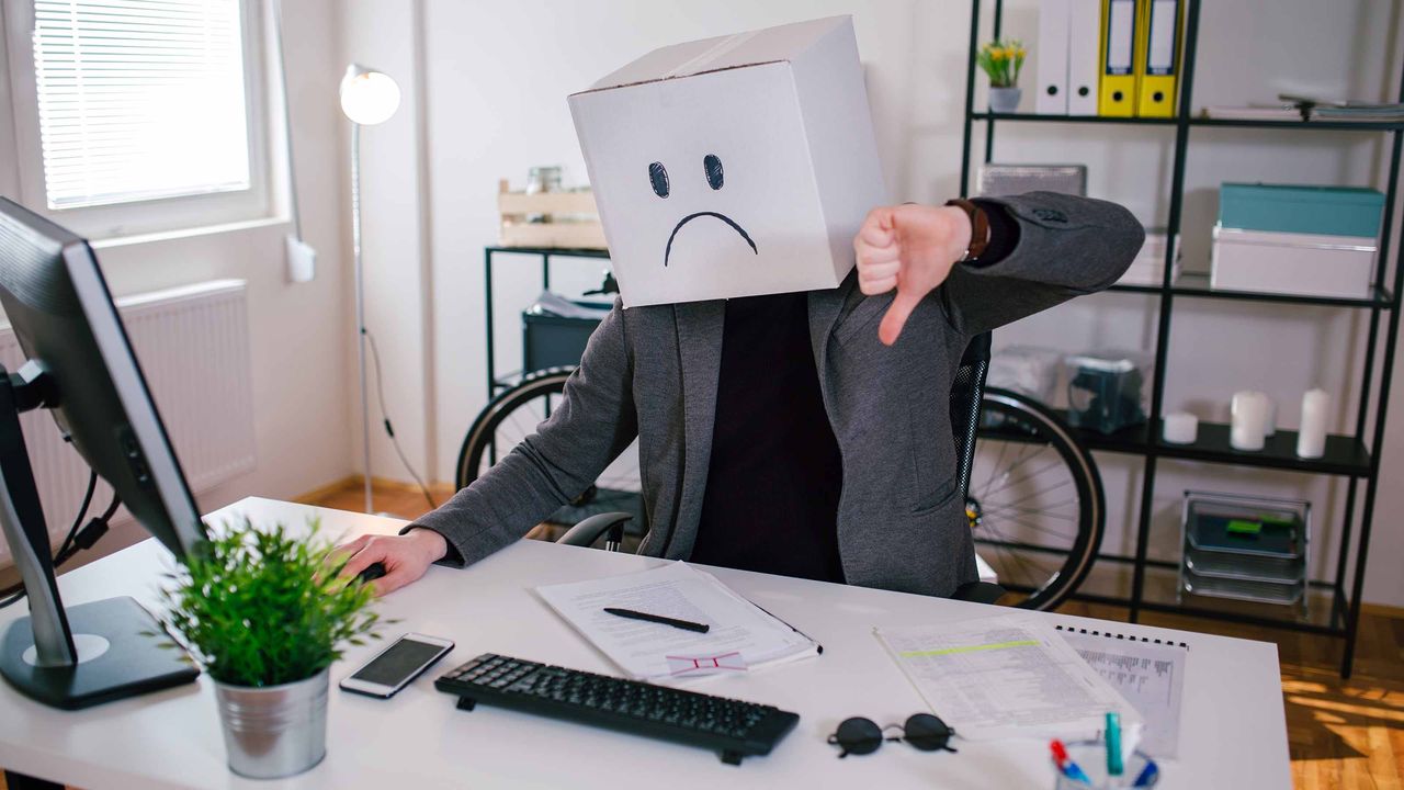 man with box on head giving thumbs down