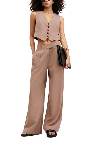 Brown All saints vest and trousers on model with black acessories.