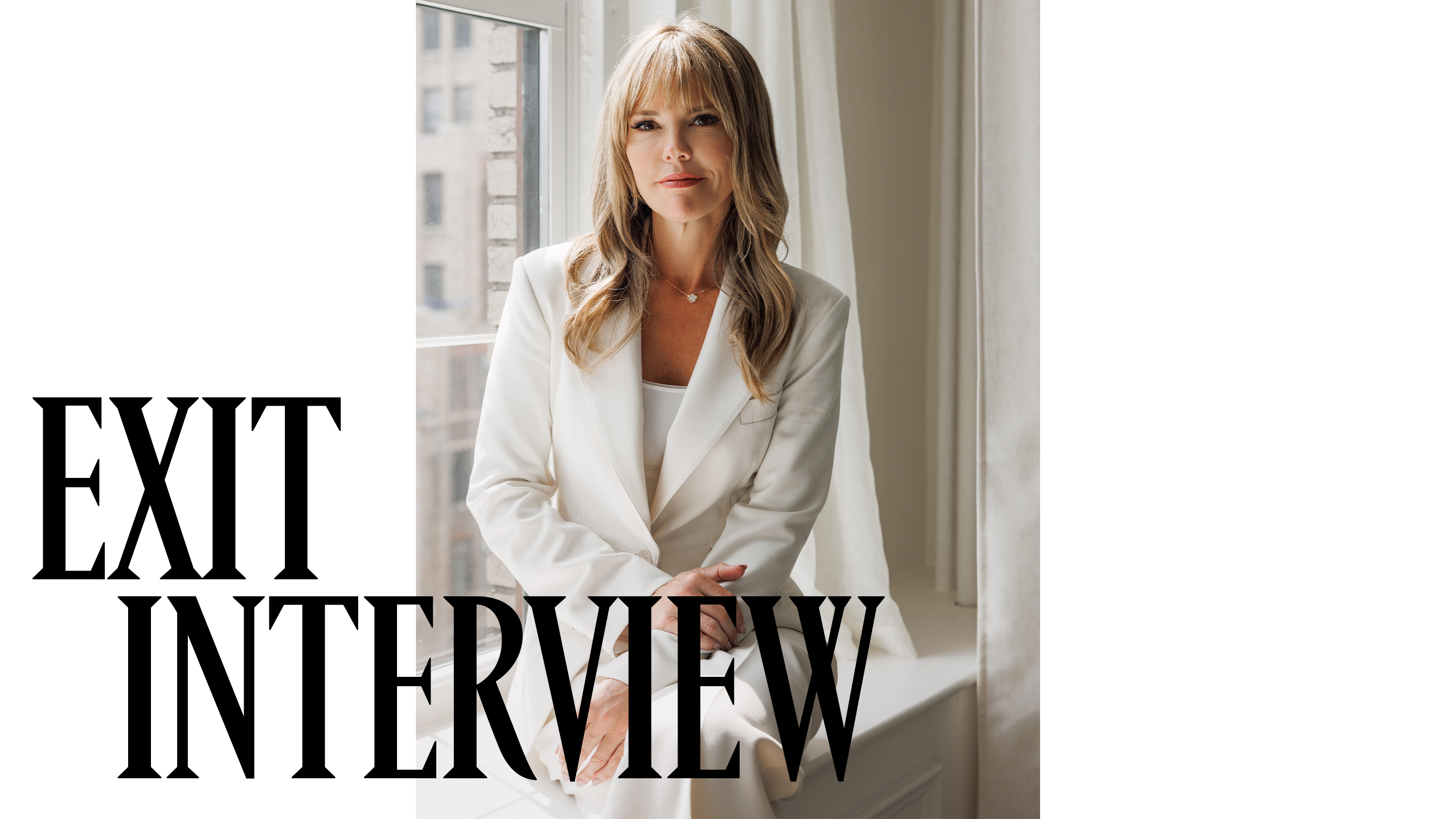Wendy McMahon wearing a white two piece suit posed seated against a white window