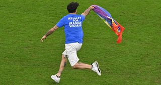 World Cup 2022 pitch invader: A man invades the pitch holding a LGBT flag as he wears a t-shirt reading "Respect for Iranian woman" during the Qatar 2022 World Cup Group H football match between Portugal and Uruguay at the Lusail Stadium in Lusail, north of Doha on November 28, 2022.