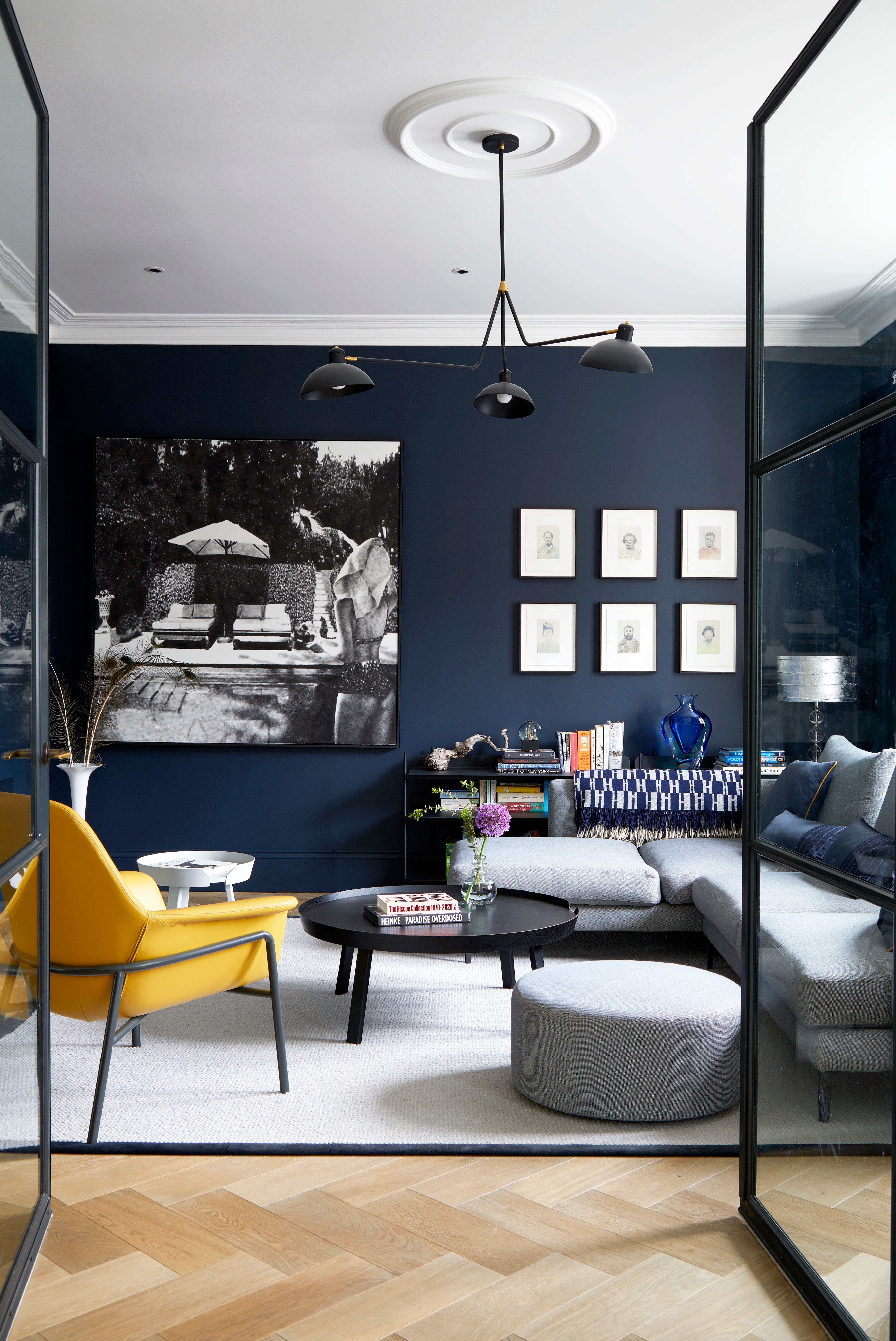 Dark blue living room with grey sofas