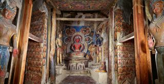 An interior shot of a temple highly decorated in indo-tibetan artworks