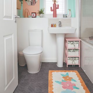 A small bathroom with a floral bath mat