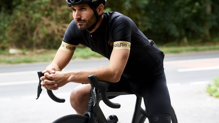 Best road bike: pictured here, a cyclist casually sitting on an ORRO road bike wearing a cycling jersey, bib shorts and a cycling helmet